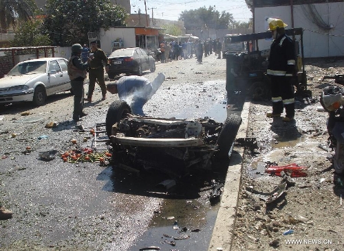 Iraqi security forces and firefighters inspect the site of a car bomb attack at Karada district in Baghdad, Iraq, March 19, 2013. At least 48 people were killed and 167 others wounded in a series of bombings and shootings in the Iraqi capital of Baghdad on Tuesday, an Interior Ministry source said. (Xinhua/Bashar)