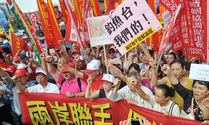 Protestors clutch placards saying 