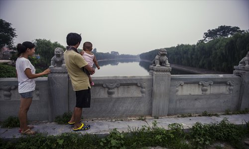 Locals gaze out on the Grand Canal from Tongyun Bridge. Local authorities have spent about 10 billion yuan restoring the little-known area. Photo: Li Hao/GT