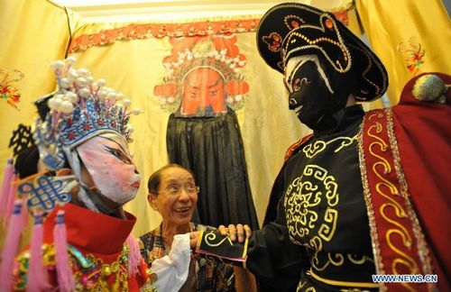 Shi Zhixuan (L), a three-year-old face change performer, practises together with her senior fellow He Yuting (R), under the instructions of He Shucheng, known as 
