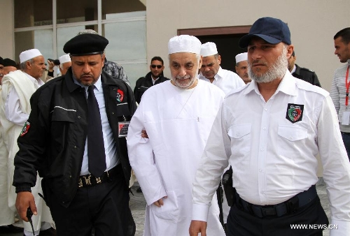 Former Libyan Prime Minister Baghdadi al-Mahmoudi (C) is escorted by police to his trial in Tripoli, capital of Libya, on Jan. 14, 2013. The trial of former Prime Minister Baghdadi al-Mahmoudi started here on Monday. Mahmoudi, who served as the last prime minister in former leader Muammar Gaddafi's administration from 2006 to 2011, fled to Tunisia in September 2011 after the armed rebels seized the Libyan capital of Tripoli during the unrest. (Xinhua/Hamza Turkia) 