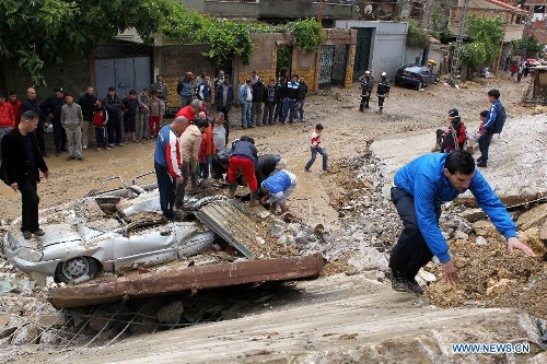 Local residents try to make the clearance of a car stuck in mud in Beni Messous suburb, in upper Algiers, Algeria, on May 22, 2013. Heavy rain poured since Tuesday in several provinces in northern part of the country, claiming the life of one citizen, injuring three others, and causing extensive damages. (Xinhua/Mohamed Kadri) 