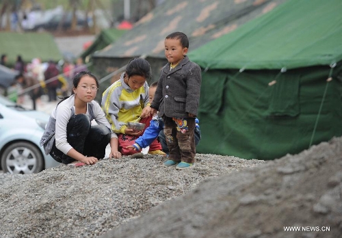 Children play outside a temporary shelter site in Lushan County of Ya'an City, southwest China's Sichuan Province, April 21, 2013. Several temporary shelter sites can be seen in Lushan County and the life supplies in these shelter sites are sufficient. A 7.0-magnitude earthquake jolted Lushan County on April 20 morning. (Xinhua/Li Jian)
