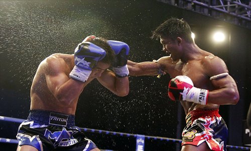 Buakaw Banchamek of Thailand (right) pummels Dong Wenfei of China on the way victory on August 10. Photo: CFP