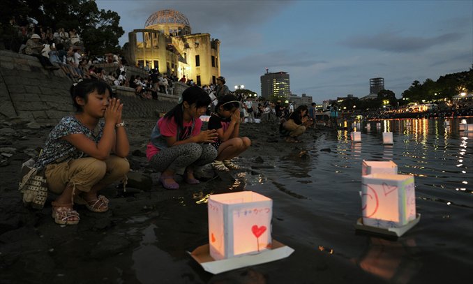 Girls pray for victims of a 1945 atomic bombing as they release paper lanterns to float on the Motoyasu River in front of the Atomic Bomb Dome in Hiroshima on Monday. Tens of thousands of people marked the 67th anniversary of the atomic bombing of Hiroshima, as a rising tide of anti-nuclear sentiment swells in post-Fukushima Japan. Photo: AFP