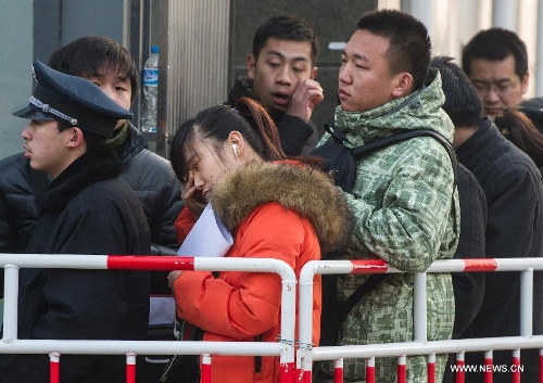 Drowsy housing agents and house owners wait for being called in due order after standing in a line all night long outside the Sixth Taxation Office of Chaoyang District Local Taxation Bureau in Beijing, capital of China, March 8, 2013. Secondhand housing transaction surges in Beijing these days as buyers and sellers are rushing to 