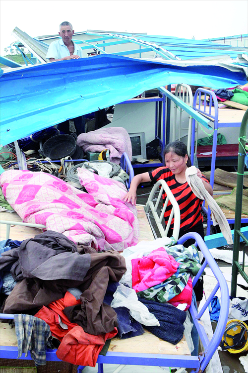 Migrant workers clean scenes at dwellings near their construction sites at Qingkou town, Jiangsu Province on Friday, after Typhoon Damrey, the 10th typhoon of the year, swept the area on Thursday. Damrey also forced the evacuation of 124,000 people in the cities of Lianyungang, Yancheng and Nantong in Jiangsu Province, according to the National Commission for Disaster Reduction. Photo: CFP
