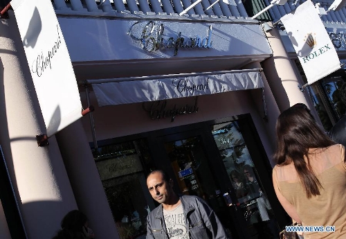 People walk past a shop of Chopard, a luxury jeweller in central Cannes May 17, 2013. More than one million US dollars worth of jewels due to be lent to movie stars at the Cannes film festival were stolen from a Novotel hotel room in the French Riviera town, a police source said. The jewels were in the safe of the room rented by an employee of Chopard, a luxury jeweller, the source said on condition of anonymity. (Xinhua/Gao Jing) 