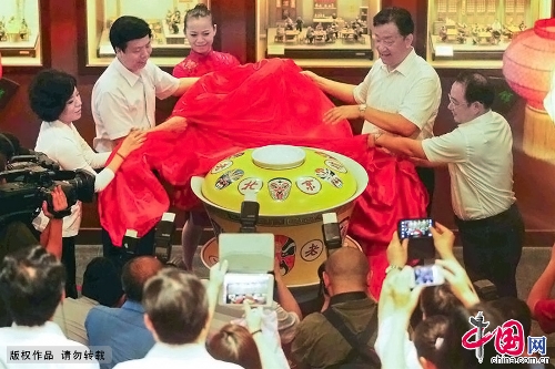 A 200kg ceramic tea bowl debuted June 30 at the Laoshe Teahouse, a world-famous Chinese folk teahouse in Beijing. The huge bowl, an enlarged version of the classical ceramic bowls with yellow lids used at the teahouse, was made by craft masters in Jingdezhen, which is known as the Porcelain Capital of China. The 75x88 cm-bowl is currently the biggest of its kind in the world. Its makers have applied to have it listed in the Guinness Book of World Records. The party at which the bowl debuted was held to mark the tenth anniversary of the death of teahouse founder Yin Shengxi.(Photo:China.org.cn)