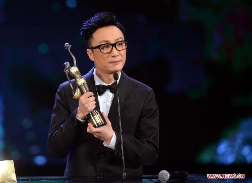 Actor Ronald Cheng holds the trophy after receiving the Best Supporting Actor award for his movie 