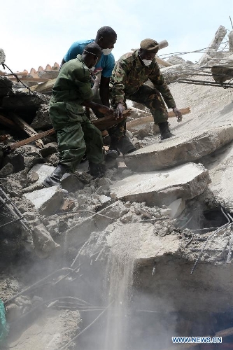 Rescuers clean up the building collapse site in downtown Dar es Salaam, Tanzania, March 29, 2013. A 16-storey building on Friday morning collapsed in Dar es Salaam, with more than 60 people got trapped in the debris. No casualties have been reported as of noon local time. (Xinhua/Zhang Ping)