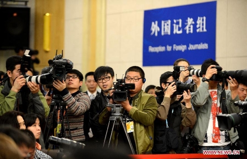 Journalists work at a news conference on China's currency policy and financial reform held by the first session of the 12th National People's Congress (NPC) in Beijing, capital of China, March 13, 2013. Governor Zhou Xiaochuan and other officials from China's central bank answered questions at the press conference. (Xinhua/Qin Qing)