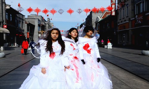 Performance artists wearing wedding dresses splattered in fake blood take a stand against domestic violence on February 14 in Qianmen, Dongcheng district. Photo: Guo Yingguang
