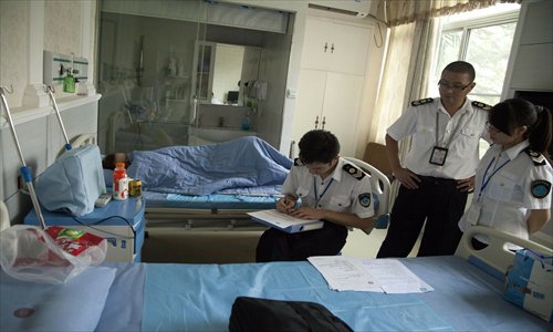 Officers investigate a woman suspected of being involved in illegal reproductive services in Shenzhen, Guangdong Province on October 16, 2012. Photo: CFP