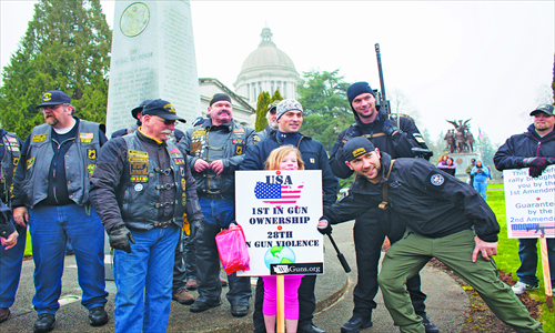 Jill Gruver, 8, (center) poses with veterans and other demonstrators during a pro-gun rally on Saturday in Olympia, Washington. Photo: AFP