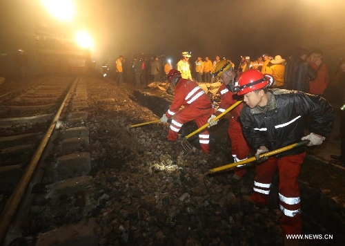 Rescuers work at the scene of a train derailment accident in the Hongshandian section of the Loudi-Shaoyang Railway in Shuangfeng County of Loudi, central China's Hunan Province, in the early hours of March 27, 2013. A freight train running on the rail line was derailed by a rainstorm-triggered landslide at around 9:18 p.m. (1318 GMT) on Tuesday. There has been no casualty reports while road maintainence workers are still working to recover traffic on the affected rail line.(Xinhua/Guo Guoquan) 