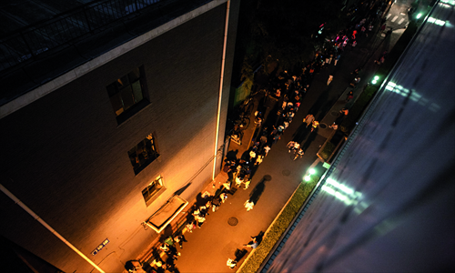 A long line stretches for nearly 100 meters outside the hospital.



