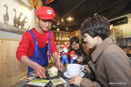 A waiter in the costume of Super Mario, a famous video game character, serves dishes at a Mario themed restaurant in Tianjin, north China, April 8, 2013. The restaurant that opened on Monday attracted many young customers due to its 