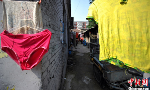 Laundry hang to dry as residents take advantage of the limited sunlight that makes it through the dark alleys. Largely made up of migrant workers and senior citizens who cannot afford better housing, many Huashiying residents return from work late at night and seldom communicate with neighbors. Photo: Jin Shuo/chinanews.com