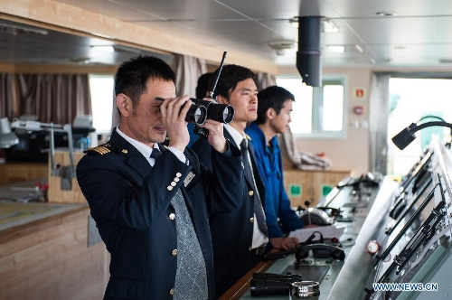 Wang Lianmiao (1st L) checks sailing conditions using telescope aboard the Maple Star on the Yangtze River in east China's Jiangsu Province, April 24, 2013. Wang Lianmiao and Zhu Hui arrived at the port of Jingjiang on the morning of April 24, 2013. Both men are inland waterway pilots from the Yangtze River Pilot Centre. Awaiting them was the Maple Star, a 180-meter-long Marshall Islands-flagged cargo ship with a gross register tonnage of over 23,000. Under their pilotage, the Maple Star was to veer 180 degrees and head downstream to the port of Zhangjiagang. The role of pilots becomes increasingly significant as foreign vessels that navigate on the Yangtze River grow in number and size. Given the intricate waterway distribution along the Yangtze, Chinese pilotage is mandatory for foreign ships entering the river's mouth to avoid accidents and protect the country's sovereignty. Zhu Hui graduated from the Navigation Institute of Jimei University and started to work as a pilot in 2005. He is still not authorized to guide vessels like the Maple Star on his own. Wang Lianmiao, who has been in the field for 20 years, was assigned to cooperate with him. The two of them know well the winds, tides, currents, shoals and reefs of the water area. With the aid of modern technology and floating signs, they are capable of issuing appropriate commands regarding the vessel's direction, route and speed. Docking and undocking large vessels like the Maple Star require particular prudence. Any mis-manoeuvre could delay the port's schedule or even damage port facilities and the vessel itself, causing economic losses. At such times, a pilot's commands are crucial to ensure navigation safety. When the Maple Star approaches its destination, Zhangjiagang, Wang Lianmiao went onto the deck to check the vessel's surroundings. 