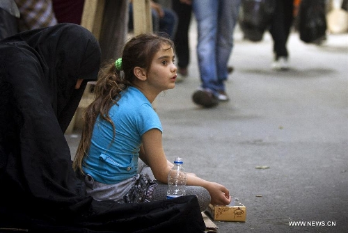 An Iranian woman and her daughter beg for money at Tehran's old main bazaar in downtown Tehran, Iran, on May 20, 2013. Economic condition of Iranian families is the core issue of the hopeful candidates for Iran's 11th presidential election, as the inflation rate of the Islamic republic, according to the Iranian Statistics Center, reached 29.8 percent in the first month of the current Iranian calendar year (March 21-April 20). (Xinhua/Ahmad Halabisaz) 