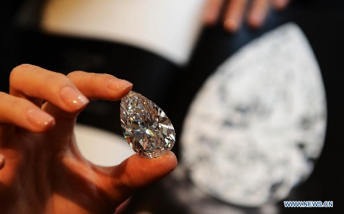 A worker shows the 101.73-carat diamond to the media at the Christie in Geneva, Switzerland, April 30, 2013. Christie will hold spring sale of Jewels auction in Geneva on May 15, 2013. Led by a truly sensational pear-shaped, D colour, flawless diamond of 101.73 carats, the sale will reach to an estimated combined total of 65 million dollars. This Type IIA Flawless gem was found at the Jwaneng mine in Botswana and took 21 months to polish. This gemstone is estimated to be sold at a price between 20 to 30 million dollars and the successful buyer will have the privilege of endowing the diamond a name. (Xinhua/Wang Siwei) 