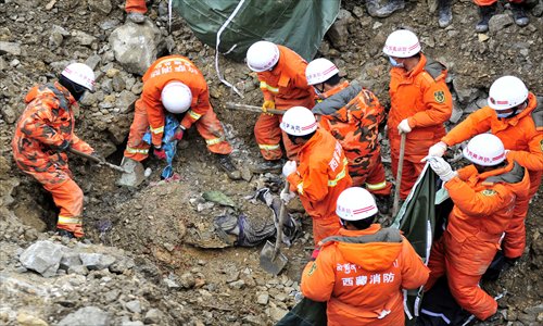 Rescuers attempt to recover the body of a victim buried in debris on Saturday after a landslide struck a workers' camp at a mine in the Tibet Autonomous Region Friday. Photo: IC