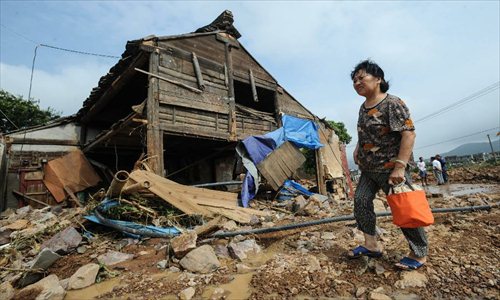 A villager stands beside a damaged house after the dam of the Shenjiakeng Reservoir breached in Daishan County, east China's Zhejiang Province, Aug. 10, 2012. The death toll from a flood that occurred Friday morning following the breach of the Shenjiakeng Reservoir has risen to ten, local rescuers said. The flood also injured 27 people. Zhejiang has been lashed by downpours over the last few days with the arrival of typhoon Haikui, which landed in the province early Wednesday morning. Photo: Xinhua