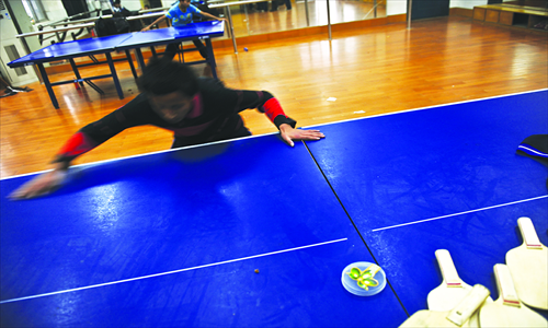 Xiao and his teammates practise moving along the tables.