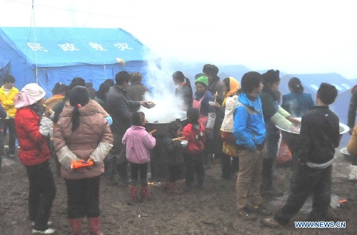 Villagers have meals in the makeshift tents near the Gaopo Village in Zhenxiong County of Zhaotong City, southwest China's Yunnan Province, Jan. 14, 2013. Forty-six people died and 2 others injured in a landslide which hit the Zhaojiagou area of Gaopo Village around 8:20 a.m. on Jan. 11. More than 500 villagers have been moved to makeshift tents near the village. (Xinhua/Chen Haining) 