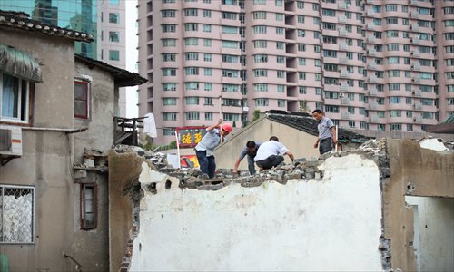 Workers use sledgehammers to bring down an old structure in Zhabei district. Photo: Cai Xianmin/GT 