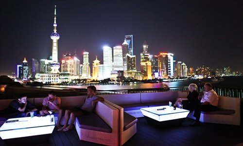 Shanghai residents cool themselves at an outdoor terrace on the Bund. Photo: CFP