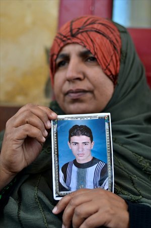 Amal al-Sayed, mother of Egyptian soldier Ahmed Abdelbadi who was kidnapped in the Sinai, holds her son's picture near the gate of the Rafah crossing border between Egypt and the Gaza Strip on Monday during a demonstration calling for the release of Egyptian security forces kidnapped by gunmen. Photo: AFP