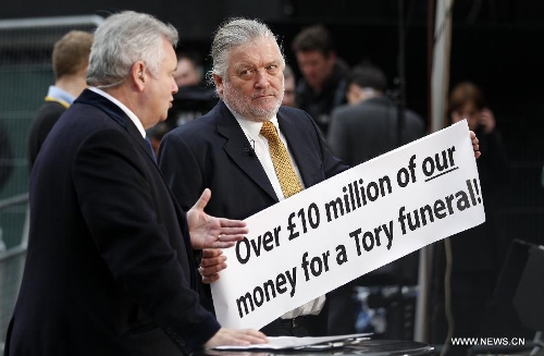 A protester (R) is interviewed by ITV before the funeral of former British Prime Minister Margaret Thatcher, outside St. Paul's Cathedral in London, Britain on April 17, 2013. The funeral of Margaret Thatcher, the first female British prime minister, started 11 a.m. local time on Wednesday in London. (Xinhua/Wang Lili)