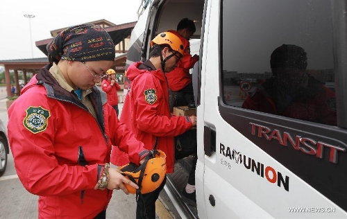 Dong Jiayue, only female member of the Ramunion Rescue, a rescue team from Hangzhou, capital of east China's Zhejiang Province, wears protective clothing at the Xinjin Service Area on the Chengdu-Ya'an Highway after 22-hour drive in Ya'an, southwest China's Sichuan Province, April 21, 2013. Six members of the Hangzhou Outdoors Emergency Rescue Team arrived in the earthquake-hit Ya'an City after driving for consecutive 22 hours on Sunday. (Xinhua/Pei Xin)  