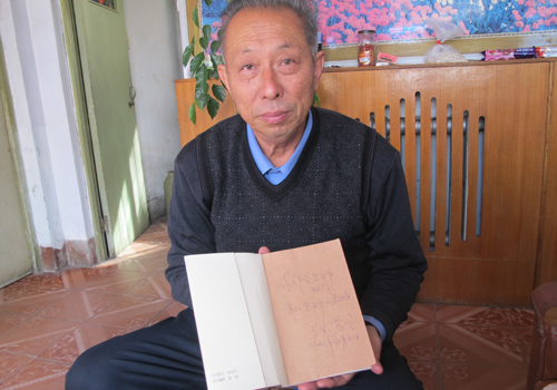 Mo's primary school teacher Zhang Zuosheng, 71, displays a book with Mo's autograph. Photo: Xu Ming/ Global Times