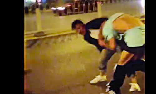Stills from a cell phone video show a foreign man being pushed from a girl and then beaten up on the street. Photos: Youku 