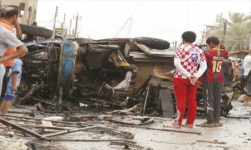 Iraqis inspect the damage following an explosion in the Kamaliya area of eastern Baghdad on Monday. Photo: AFP
