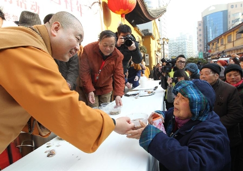  A monk distributes porridge to citizens at the Yufo (Jade Buddha) Monastery in Shanghai, east China, Jan. 19, 2013, to celebrate the traditional Laba Festival. Laba literally means the eighth day of the 12th lunar month. The Laba Festival is regarded as a prelude to the Spring Festival, or Chinese Lunar New Year, the most important occasion of family reunion, which falls on Feb. 10 this year. Eating porridge is an old tradition on the Laba Festival in China. Many temples also have the tradition of offering porridge to the public to commemorate Buddha and deliver his blessings to both believers and non-believers. (Xinhua/Ren Long) 