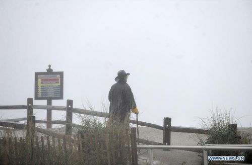 A man watches and feels the gusts along the beach in Atlantic City, New Jersey, the United States, October 29, 2012. Hurricane Sandy is on Monday churning its way towards the US East Coast, poised to make landfall near Atlantic City on Jersey Shore in the evening. The city itself is like a ghost town, with casinos shuttered, tourists fled and many parts of the town inundated in knee-high water. Photo: Xinhua
