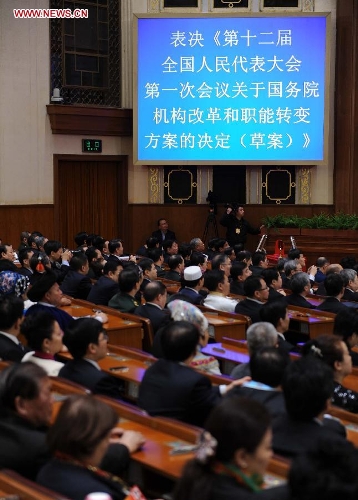  Deputies vote on a draft resolution on the plan of institutional reform and functional transformation of the State Council during the fourth plenary meeting of the first session of the 12th National People's Congress (NPC) at the Great Hall of the People in Beijing, capital of China, March 14, 2013. Chairman, vice-chairpersons, secretary-general and members of the 12th NPC Standing Committee, president and vice-president of the state, and chairman of the Central Military Commission of the People's Republic of China will also be elected here on Thursday. (Xinhua/Li Tao)