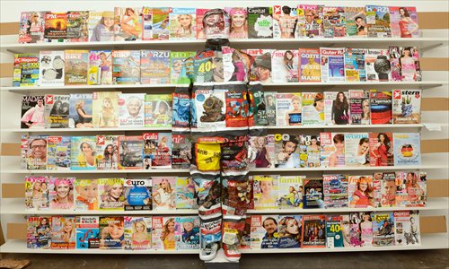 Chinese artist Liu Bolin stands painted in front of a wall with different magazines in an art association in Germany, on Wednesday. In his art works he blends his person with the background, with the help of  local art students. 
Photo: CFP