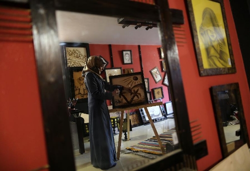 Palestinian artist Salwa Sbakhi paints using coffee at her studio in Gaza City, on Jan 22, 2013. Sbakhi has studied fine arts at Al-Aqsa University in Gaza and participated in numerous local exhibitions. (Xinhua/Wissam Nassar) 