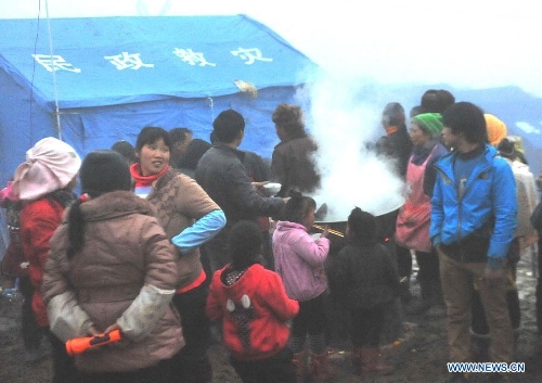 Villagers have meals in the makeshift tents near the Gaopo Village in Zhenxiong County of Zhaotong City, southwest China's Yunnan Province, Jan. 14, 2013. Forty-six people died and 2 others injured in a landslide which hit the Zhaojiagou area of Gaopo Village around 8:20 a.m. on Jan. 11. More than 500 villagers have been moved to makeshift tents near the village. (Xinhua/Chen Haining)