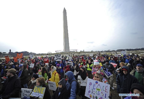 People hold signs against gun violence in front of the Washington Monument during a march in Washington D.C., capital of the United States, Jan. 26, 2013. Thousands of people, including family members of victims and survivors of shootings at Virginia Tech University, Sandy Hook elementary school and others, took part in a march for stricter gun control laws here on Saturday. (Xinhua/Zhang Jun) 