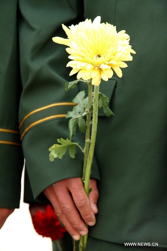 A soldier presents a flower to a monument during a memorial ceremony held at Yuhuatai Martyr Cemetery in Nanjing, capital of east China's Jiangsu Province, March 30, 2013, to pay respect to martyrs ahead of the Qingming Festival, or Tomb Sweeping Day, which falls on April 4 this year. (Xinhua/Xu Yijia)