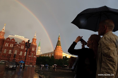 People take photos of a rainbow arching above Moscow's Red Square after a heavy rain on May 22, 2013. (Xinhua/Jiang Kehong)
