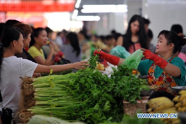 Citizens buy vegetables at a market in Sanya, South China's Hainan Province, July 9, 2012. China's Consumer Price Index (CPI), a main gauge of inflation, grew by 2.2 percent year on year in June, down from 3 percent in May, the National Bureau of Statistics (NBS) said on Monday. Photo: Xinhua