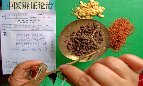 A TCM doctor prescribes medicines at a hospital in Yichang, Hubei Province, on October 17, 2006. Photo: CFP
