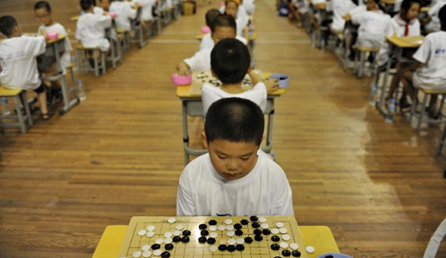 Children play chess, Chinese chess and other mind games in Nanchang, capital of east China's Jiangxi Province, Aug. 8, 2012. More than 200 people participated in the activities. Photo: Xinhua